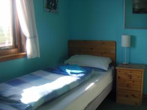 a bedroom with a bed and a dresser and a window at Easterhoull Chalets in Scalloway