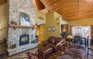 a living room with a couch and a stone fireplace at Chalet 5 Aspens in Prescott