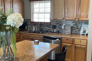 a kitchen with wooden cabinets and a vase of flowers on a counter at Entire residential home -Omaha in Omaha