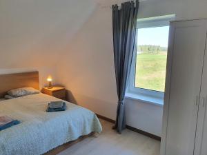 a bedroom with a bed and a large window at Villa Monciske in Palanga