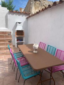 una mesa de madera y sillas con un jarrón. en Casa Santa Maria I con barbacoa, en Arévalo