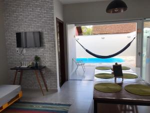 a living room with a table and a hammock at Casa Sol com piscina in Balneario Barra do Sul