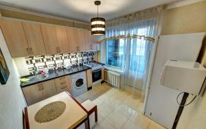 a kitchen with a sink and a stove top oven at ТОП 1к квартира метро Лукьяновка, Юрия Ильенка 49 in Kyiv