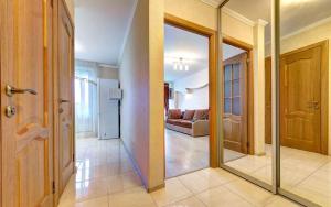 a hallway with a mirror and a living room at 1к квартира метро Лук'янівка, Юрія Іллєнка 49 in Kyiv