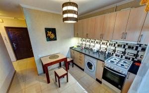 a kitchen with a stove and a table in it at 1к квартира метро Лук'янівка, Юрія Іллєнка 49 in Kyiv +2 photos