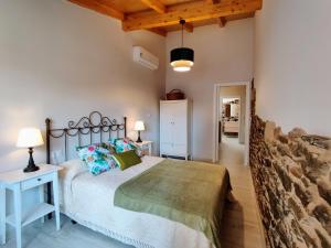 a bedroom with a large bed and a wooden ceiling at La Casita de la Ribeira Sacra in Monforte de Lemos