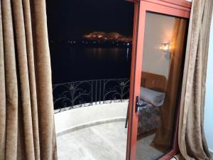 a room with a balcony with a view of the water at Nile queen Apartments for Rent in Luxor