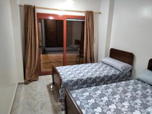 a bedroom with two beds and a window with a view at Nile queen Apartments for Rent in Luxor