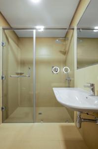 a bathroom with a glass shower and a sink at Nordic Hotel Lagos in Lagos