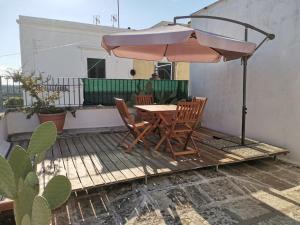 einen Tisch und Stühle auf einer Terrasse mit einem Sonnenschirm in der Unterkunft Appartamento Sant'Antonio in Castro di Lecce