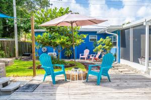 2 sillas azules y una sombrilla en el patio en The Blue House Fort Lauderdale Airport/Cruise, en Fort Lauderdale