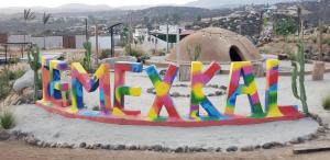 a sign that says mum in the sand in the desert at TEMEXKAL RESORT in Ensenada