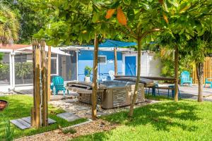 un patio trasero con bañera de hidromasaje y árboles en The Blue House Fort Lauderdale Airport/Cruise, en Fort Lauderdale