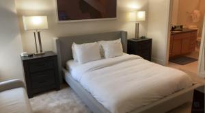 a bedroom with a bed with two night stands and two lamps at National at Loudoun in Ashburn