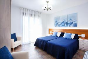 a bedroom with a blue bed and a chair at Casa rural Torre Buena Vista a 40 minutos de Valencia con gran jacuzzi y vistas maravillosass in Benafer