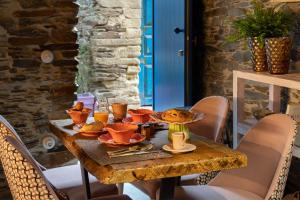a wooden table with food and drinks on it at Story Studio Piódão - Heritage in Piódão