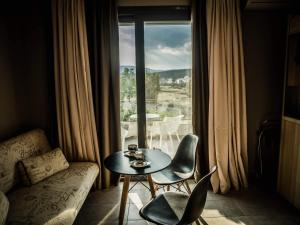 sala de estar con mesa, sillas y ventana en Villa Marelia apartments, en Aliveri