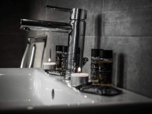 a bathroom sink with two candles and a mirror at Villa Marelia apartments in Aliveri