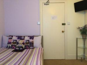 a bedroom with a bed with a teddy bear on it at Arun Sands Rooms in Littlehampton