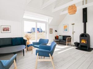 a living room with blue chairs and a fireplace at 10 person holiday home in Skagen in Skagen