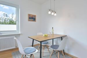 a dining room with a table and four chairs at Dat Ferienhus - Verpuusten in Malente