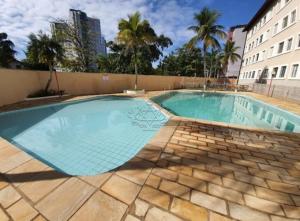 a large swimming pool in the middle of a building at Apartamento Dona Frida Prainha com WiFi pé na areia in Caraguatatuba