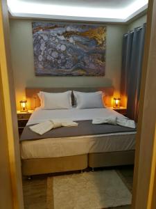 a bedroom with a bed with a painting on the wall at KERAME PARADISE VILLA in Agios Kirykos