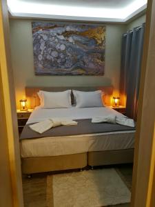 a bedroom with a bed with a painting on the wall at KERAME PARADISE VILLA in Agios Kirykos +35 photos