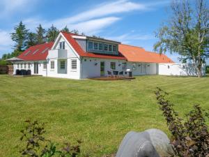 洛肯的住宿－14 person holiday home in L kken，庭院上一座白色房子,屋顶橙色
