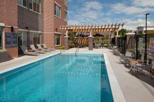 une grande piscine avec des chaises et un bâtiment dans l'établissement Hyatt Place Murfreesboro, à Murfreesboro