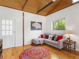 een woonkamer met een bank en een tapijt bij Blue Apple Lodge in Bilpin