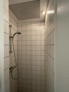 a bathroom with a shower with white tiles at ApartmentInCopenhagen Apartment 1376 in Copenhagen
