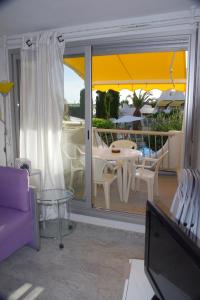 sala de estar con balcón con mesa y sillas en La Calypso, en La Grande-Motte