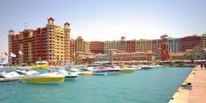 kilka łodzi zaparkowanych w porcie z budynkami w obiekcie Porto Marina Resort & Spa Al Alamein w mieście El Alamein
