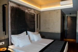 a bedroom with a large bed with white pillows at Adonis City Hotel in Patra