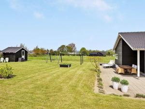 um quintal com um baloiço na relva em 7 person holiday home in Nordborg em Nordborg