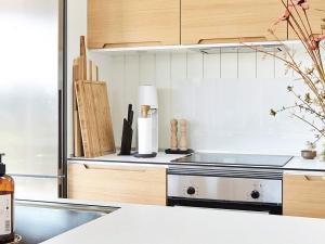 a kitchen with wooden cabinets and a stove top oven at 8 person holiday home in Slagelse in Slagelse