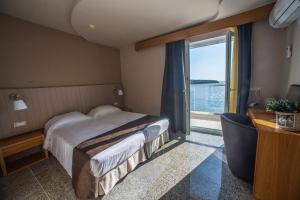 a hotel room with a bed and a large window at El Greco Hotel in Agios Nikolaos