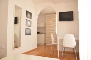 a living room with a table and chairs and a television at Villa Katerina in Ohrid