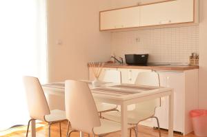 a kitchen with a white table and white chairs at Villa Katerina in Ohrid +22 photos