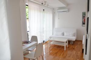 a living room with a white couch and a table at Villa Katerina in Ohrid