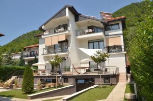 a large white building with a hill in the background at Villa Katerina in Ohrid
