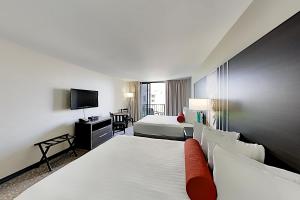 een hotelkamer met twee bedden en een televisie bij Aqua Palms Waikiki Ocean View Lanai Parking Included in Honolulu