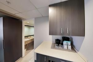 a kitchen with brown cabinets and a counter top at Aqua Palms Waikiki Ocean View Lanai Parking Included in Honolulu