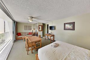 ein Schlafzimmer mit einem Bett, einem Tisch und einem Sofa in der Unterkunft Pacific Monarch 901 condo in Honolulu