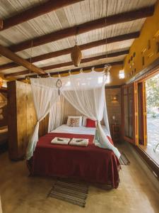 a bedroom with a bed with a canopy at Canto de Jurema Corumbau Glamping, Chalé, Acolhimento e Sustentabilidade in Corumbau