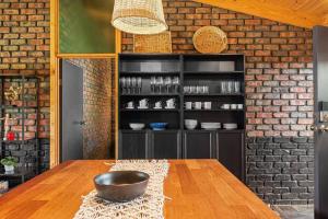 eine Küche mit einem Holztisch und einer Ziegelwand in der Unterkunft Black Pearl - Aldinga Beach - C21 SouthCoast Holidays in Aldinga Beach