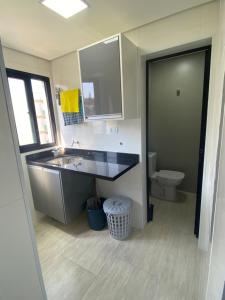 un bagno con lavandino e WC di Apto a 2 min a Pé da Praia - Edificio Monte Carmel a Guarujá Altre 17 foto