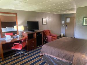 a hotel room with a bed and a television at Economy Inn North Randall in North Randall