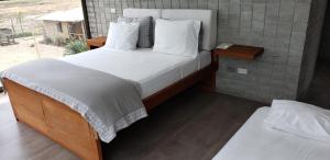 a bedroom with a large bed with white sheets and pillows at Casa frente al Mar EL PARAISO, Cojimies in Pedernales